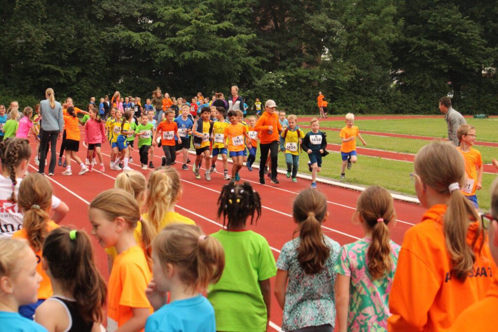 Kinderen rennend op de atletiekbaan van AV Passaat tijdens de schoolatletiekdag